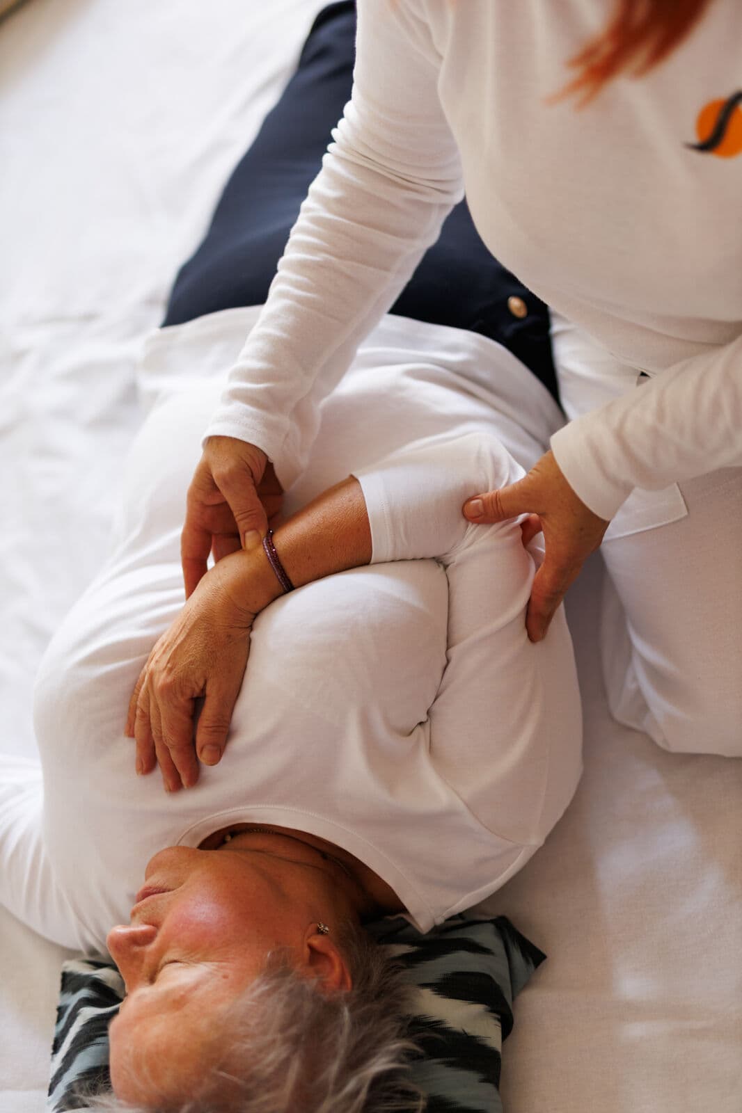 Shiatsu-Sitzung in der Praxis, auf der Matte vor einem Shoji-Paravent